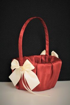 a red bag with a white bow on the front and side, sitting on a table