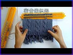 two hands are working on a weaving project with yarn and plastic combs in the background