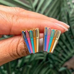 a person is holding some colorful pins in their hand