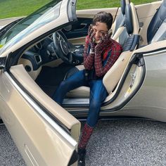 a man sitting in the driver's seat of a car talking on his cell phone