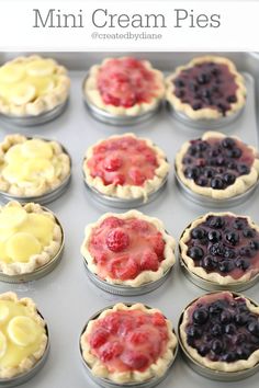 mini cream pies in tins with blueberries and raspberries on top