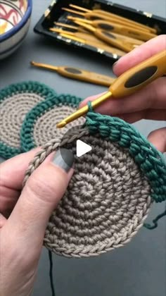 someone is crocheting together to make a basket with yarn and scissors on the table