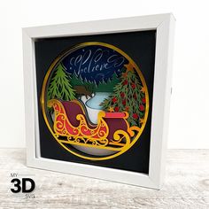 a christmas ornament in a white frame on a wooden table