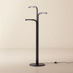 a black floor lamp with two lights on each side and one light on the other