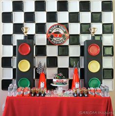 a table topped with traffic lights next to a wall covered in black and white tiles