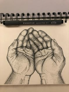 a drawing of two hands holding something in each other's palms, on top of a notepad