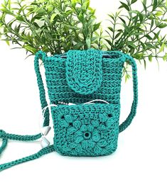 a crocheted purse and cell phone case sitting next to each other