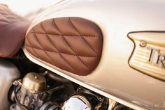 a close up view of the front end of a motorcycle with brown leather seat covers