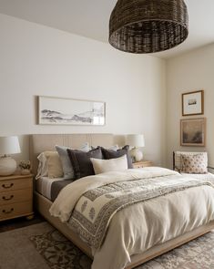 a bedroom with a large bed and wicker basket hanging from the ceiling above it