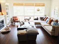 a living room filled with furniture and a fire place in front of a large window