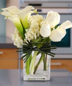 a vase filled with white flowers on top of a counter