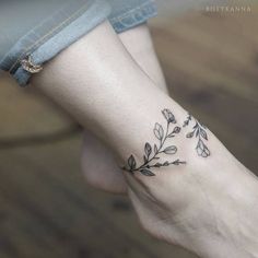 a woman's foot with a small tattoo design on the left side of her leg