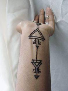 a person's arm with an arrow tattoo on the left side of their arm