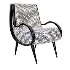 a black and white chair with an intricate design on the armrests, sitting in front of a white background