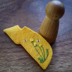 a yellow piece of fabric with flowers on it sitting next to a wooden peg board