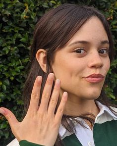 a woman holding her hand up to her face