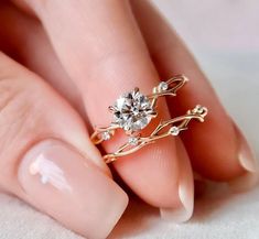 a woman's hand with a gold ring and diamond set on her finger,