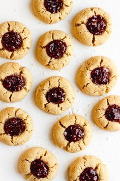 peanut butter and jelly cookies are arranged on a baking sheet, ready to be eaten