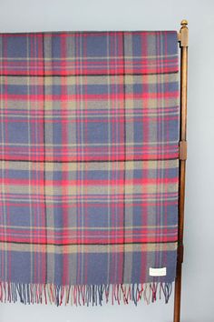 a blue and pink plaid blanket hanging from a wooden chair