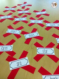 red and white cut out pieces of paper on top of a wooden table with words