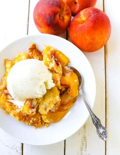 a white bowl filled with food next to two peaches