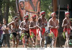 men dressed in traditional clothing and holding spears