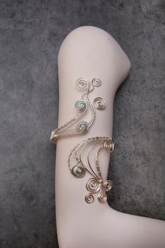 "Add a stylish and individual touch to your outfits with one of my hand crafted arm cuff. Beautiful  and elegant arm cuff is carefully handcrafted made out of silver plated copper wire. And wrapped with light mint green shell pearls 12mm. Measurement :  The length of design is 6 inches and  armcuff is adjustable from  is 8.5\" to 15.50\" in circumference. If you require any further information, feel free to contact me. Shipping: Packages are sent with Royal mail with an estimated delivery times: Elegant Spiral Hand Wrapped Jewelry, Unique Silver Cuff Bracelet For Party, Elegant Silver Wire Wrapped Cuff Bracelet, Silver Wire Wrapped Bangle Cuff Bracelet, Elegant Hand-wrapped Silver Cuff Bracelet, Elegant Hand Wrapped Silver Cuff Bracelet, Silver Spiral Metal Cuff Bracelet, Spiral Silver Cuff Bracelet, Adjustable Silver Wire Wrapped Cuff Bracelet