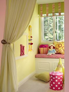 a child's bedroom with yellow walls and pink curtains on the window sill