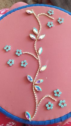 a pink cake decorated with blue flowers and jewels