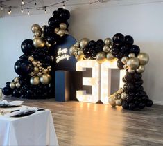 a table with black and gold balloons in the shape of letters that spell it's 50th