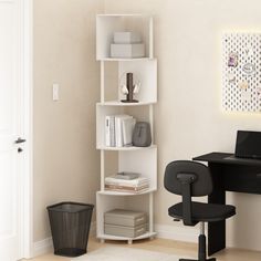 a computer desk with a laptop on top of it next to a white book shelf