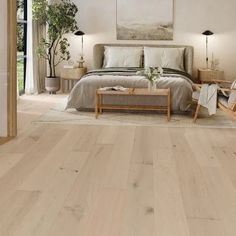 a bedroom with white walls and wood floors