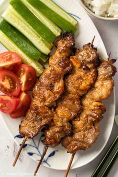 chicken skewers with vegetables and rice on a plate