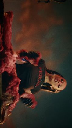 a woman standing in front of a mirror with blood on the floor and walls behind her