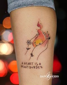 a woman's leg with a tattoo on it that says, a heart is a heavy burden