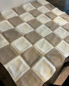 a brown and white blanket sitting on top of a wooden floor