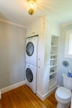 a washer and dryer in a small room with wood flooring on the wooden floors