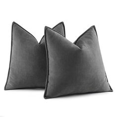 two gray pillows sitting next to each other