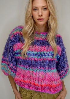 a woman with blonde hair wearing a multicolored sweater