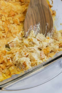 a casserole dish filled with food and a wooden spoon in the casserole