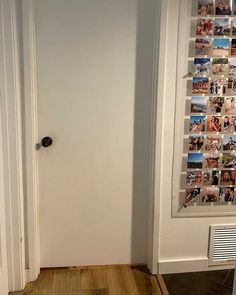 an open door with pictures on the wall and wood flooring in front of it