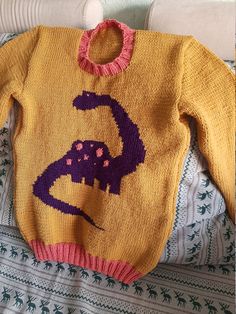 a sweater with an image of a dinosaur on it