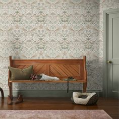 a wooden bench sitting on top of a hard wood floor next to a wall paper