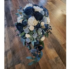 a bouquet of blue and white flowers sitting on top of a wooden floor