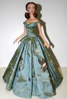 a barbie doll wearing a blue dress with butterflies on it's chest and shoulder