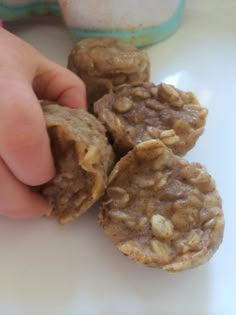 a person is picking up some cookies from the table with their hand on top of them