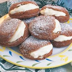 a plate filled with cookies covered in icing on top of a blue and yellow table cloth