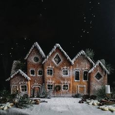 a group of gingerbread houses on top of a table covered in snow