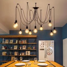 a dining room table with plates and wine glasses on it, hanging from the ceiling