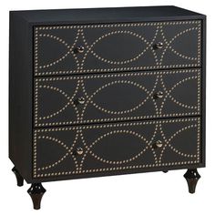 a black and gold dresser with studded accents on the front, two drawers and one door